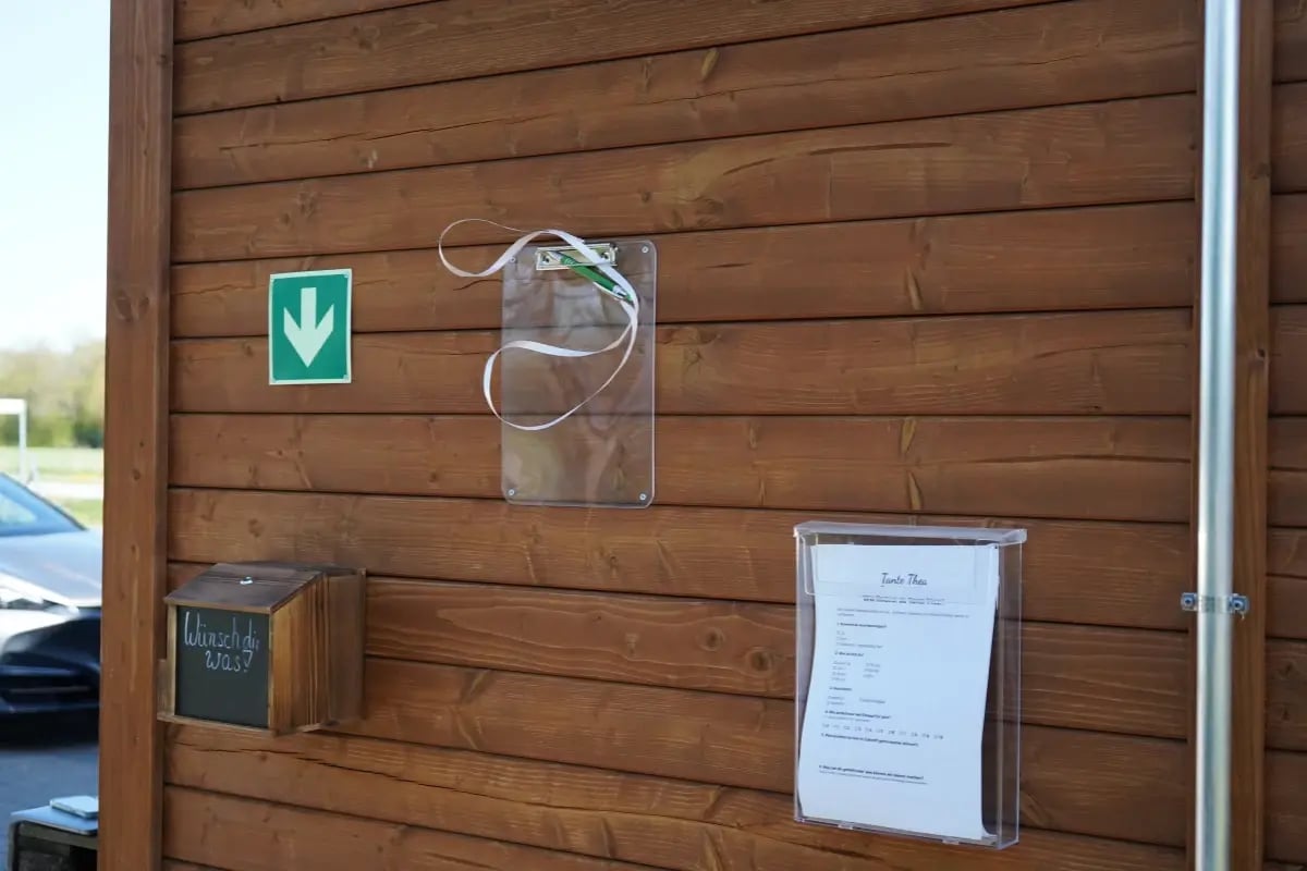 Servicebereich an der Außenwand des Hofladens Hemdingen mit Hinweisschildern.