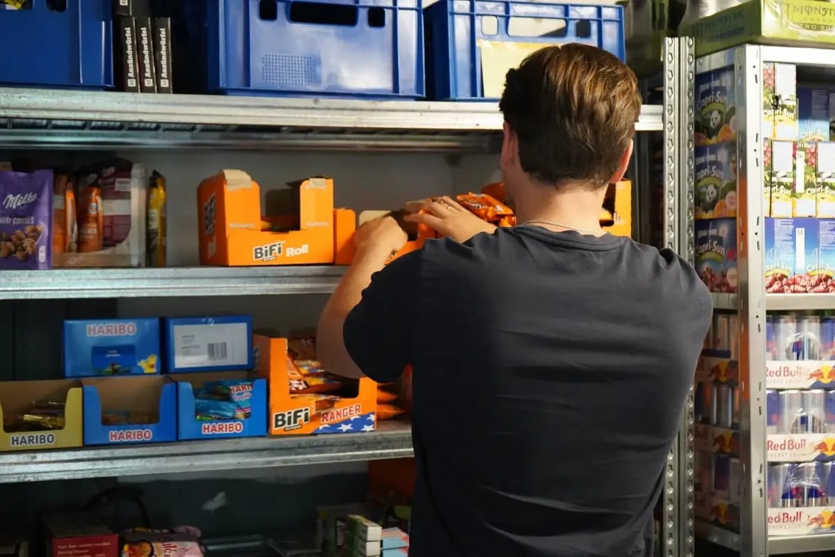 Ein Mitarbeiter bereitet Produkte für die Befüllung der Tante Thea Verkaufsautomaten vor.
