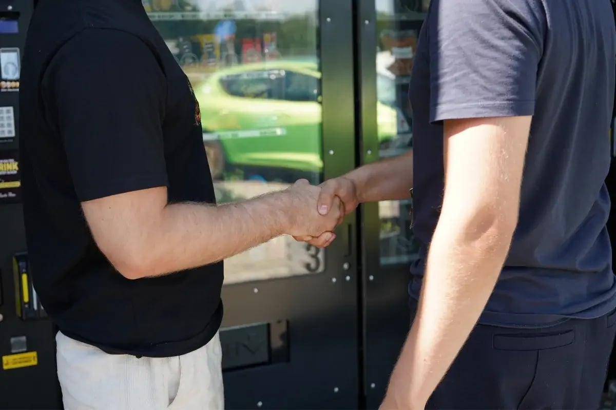 Zwei Ansprechpartner besprechen eine Zusammenarbeit vor einem Tante Thea Standort.